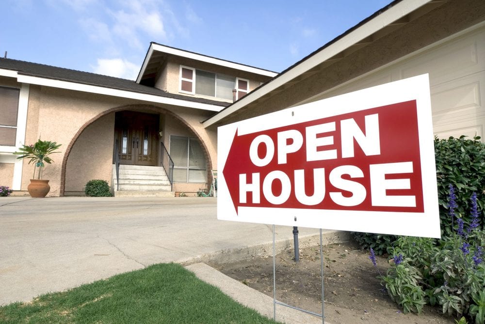 Top Tips for Buying a New Build House Graphic to show a home for sale shows the open house sign on a sunny afternoon.