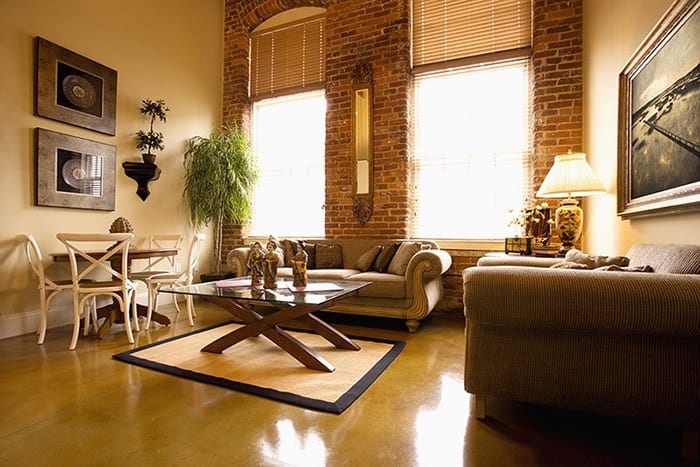 Graphic to show Interior of furnished living room with large windows and brick wall. Horizontal shot.